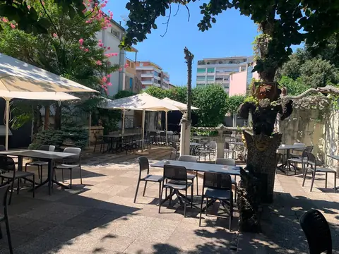 Ampio giardino esterno con tavoli e ombrelloni